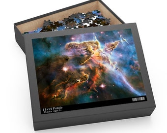 May include: A 11x14 inch jigsaw puzzle with 252 pieces, featuring a colorful image of the Carina Nebula. The puzzle is in a black box with the text "11x14 Puzzle 252 pcs Ages 9+" on the front.
