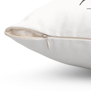 May include: A white pillow with a zipper closure. The zipper is visible and is open.