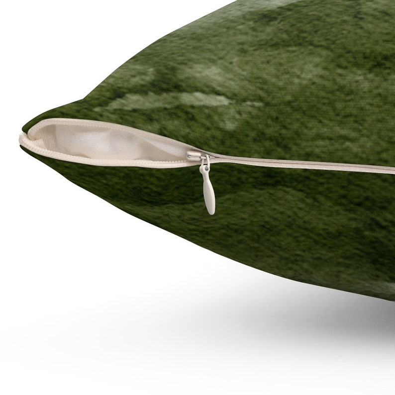 May include: A green throw pillow with a zipper closure. The pillow has a soft, fuzzy texture.