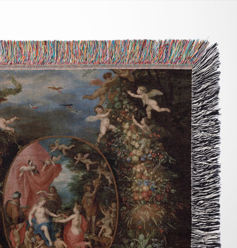 May include: A woven tapestry throw blanket featuring a colorful Renaissance-style painting of a group of people in a garden setting. The painting is surrounded by a border of cherubs and fruit.