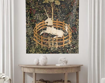 May include: A rectangular wall tapestry featuring a white unicorn resting inside a circular wooden fence. The background is a dark, dense millefleur pattern filled with various colorful flowers, green foliage, and a tall tree centered behind.
