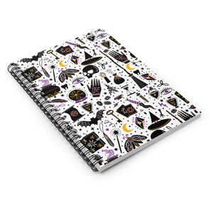 May include: A white spiral notebook with a black and white pattern of witchy symbols and objects. The pattern includes a witch's hat, a cauldron, a wand, a crystal ball, a crescent moon, a bat, a key, a skull, a potion bottle, a hand with an eye, a broom, and a book. The notebook is perfect for taking notes, writing down spells, or journaling.
