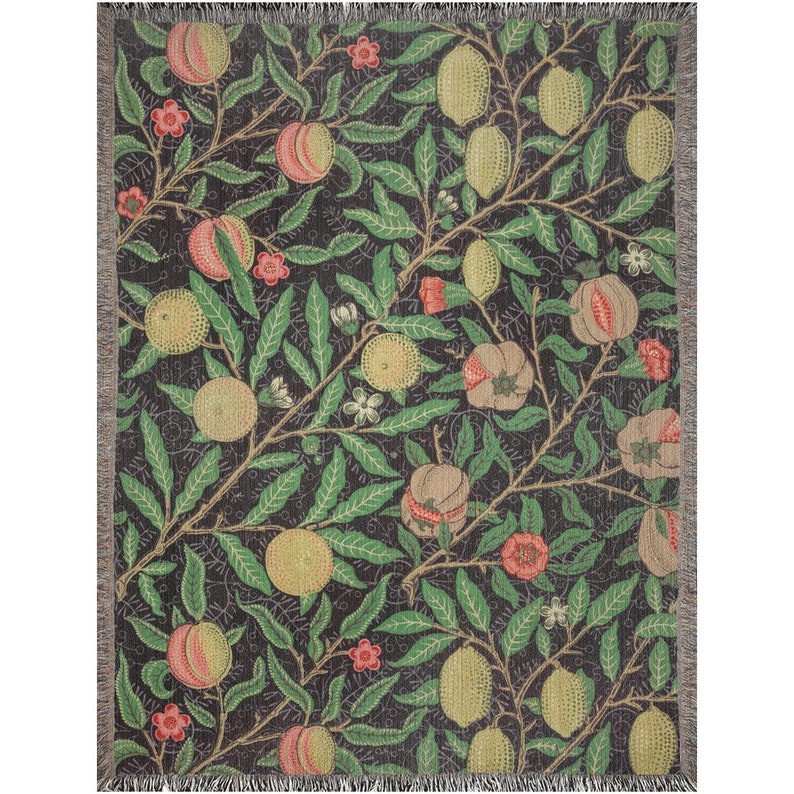 May include: A woven throw blanket with a repeating pattern of green leaves, yellow lemons, and red pomegranates on a dark background.