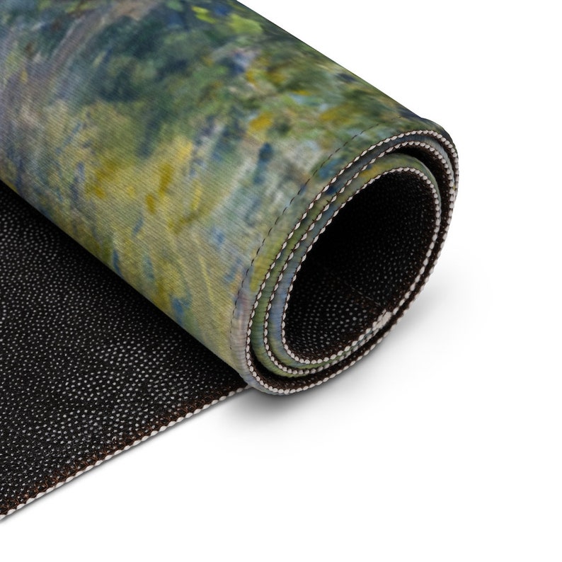 May include: A rolled up rug with a green, blue, and yellow abstract pattern. The rug has a black non-slip backing.