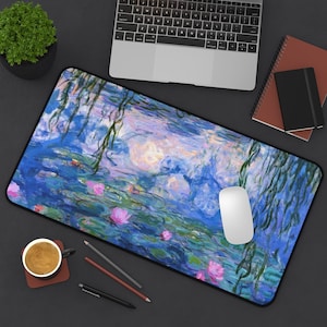 Peut inclure: Un tapis de souris bleu et vert avec une peinture de nénuphars et une souris blanche dessus.