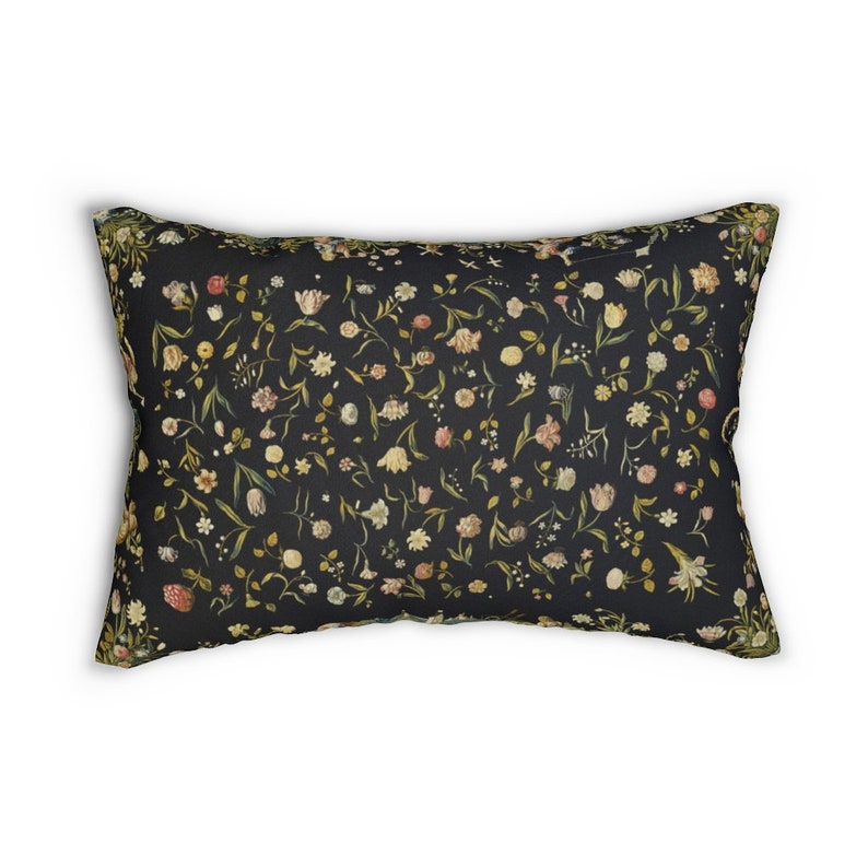 Puede incluir: Una almohada negra con un patr&oacute;n floral que presenta una variedad de flores en tonos de rosa, blanco y amarillo. Las flores est&aacute;n dispuestas en un patr&oacute;n aleatorio sobre un fondo oscuro.
