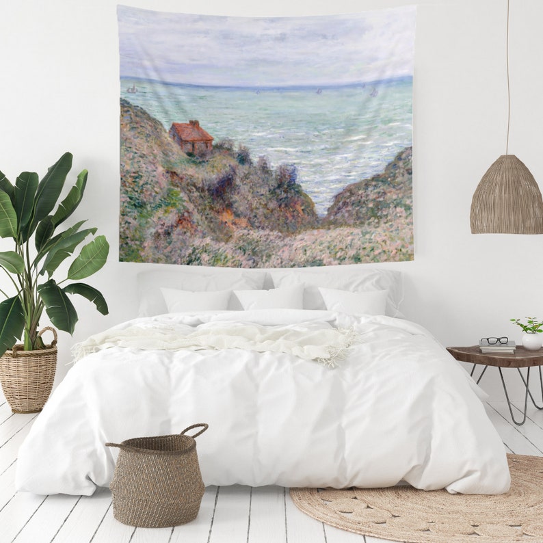 May include: A tapestry featuring a painting of a small house on a cliff overlooking a blue and green ocean. The sky is a light blue with white clouds. The painting is in a painterly style with visible brushstrokes.