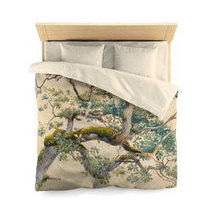 May include: A duvet cover featuring a detailed watercolor painting of a large tree with green leaves and branches. The background is a light beige color.