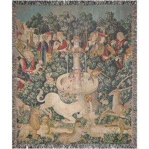 May include: A tapestry depicting a unicorn being captured by hunters in a woodland setting. The unicorn is white and is being led by a rope to a fountain. The hunters are dressed in medieval clothing and are surrounded by trees and other animals.
