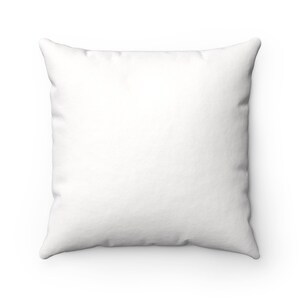 May include: A white square pillow with a smooth, soft fabric surface.