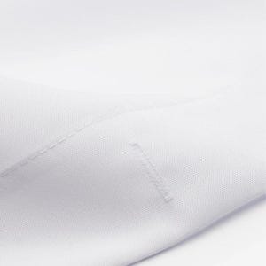 The image is a close-up of a white fabric, possibly a shirt or a piece of clothing.