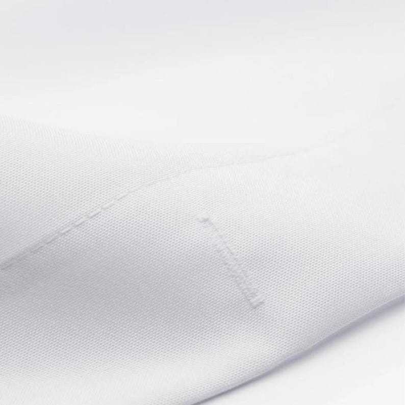 The image is a close-up of a white fabric, possibly a shirt or a piece of clothing.