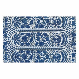 May include: A rectangular, white and blue floral patterned textile. The design features a repeating pattern of blue flowers and leaves, with a central oval-shaped design. The border is decorated with small blue flowers.