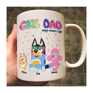 May include: White ceramic mug with a colourful "GIRL DAD" design and "Happy Father's Day" text. Features cartoon characters of a dog and a poodle. A perfect gift for Father's Day.