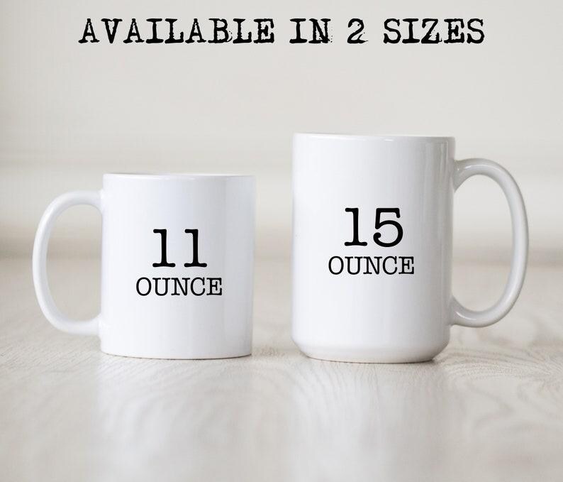 May include: Two white ceramic mugs with black text. The smaller mug is 11 ounces and the larger mug is 15 ounces.