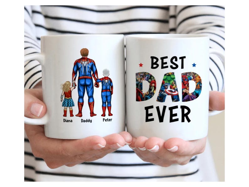 May include: Two white ceramic mugs. One mug features a superhero design with the words "Diana, Daddy, Peter". The other mug says "BEST DAD EVER" with a colourful comic book design.