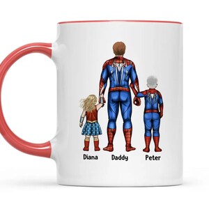 May include: White ceramic mug with a red interior and handle. The mug features a graphic of a family dressed as superheroes: Spider-Man, Wonder Woman, and a child in a Spider-Man suit. The names "Diana", "Daddy", and "Peter" are printed below the characters.