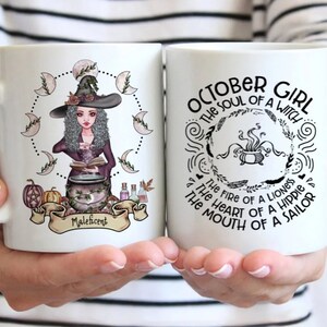 Puede incluir: Dos tazas de cer&aacute;mica blanca con texto negro e ilustraciones. Una taza presenta una bruja con un caldero y el texto "Maleficent". La otra taza presenta un caldero con el texto "OCTOBER GIRL THE SOUL OF A WITCH THE FIRE OF A LIONESS THE HEART OF A HIPPIER THE MOUTH OF A SAILOR".