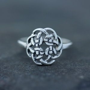 May include: A silver ring featuring a Celtic knot design.