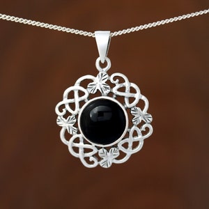 May include: A silver pendant necklace featuring a black onyx stone set within a Celtic knot design.