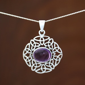 May include: A silver Celtic knot pendant featuring a purple amethyst gemstone in the centre.