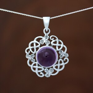May include: A silver pendant necklace featuring a purple amethyst gemstone set within a Celtic knot design.