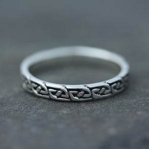 Op de afbeelding: Een zilveren ring met een Keltisch knoopontwerp. De ring is eenvoudig en elegant en zou een geweldig cadeau zijn voor een speciale gelegenheid.
