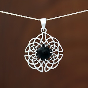 May include: A silver Celtic knot pendant with a black onyx stone in the centre. The pendant is hanging from a silver chain.