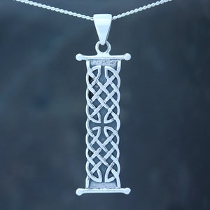 Puede incluir: Pendiente de plata con un diseño de nudo celta en forma de la letra I. El pendiente está colgado de una cadena de plata.
