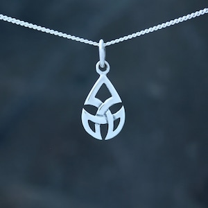 May include: A silver pendant necklace with a teardrop-shaped design featuring a Celtic knot pattern.