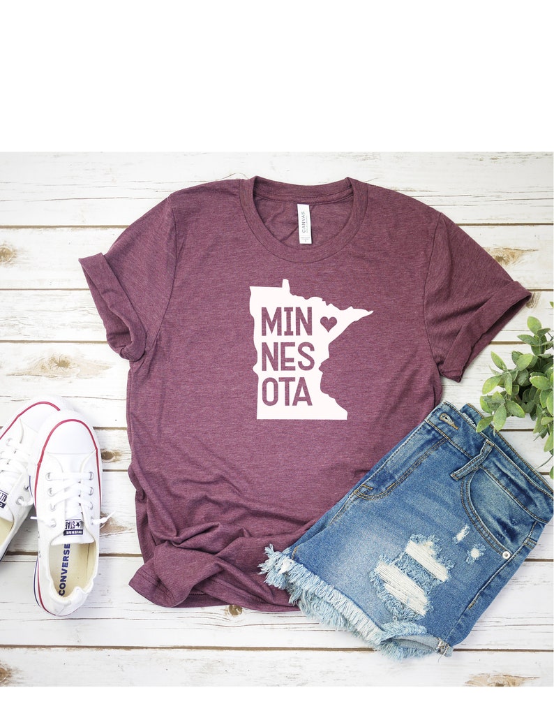 May include: A maroon t-shirt with a white outline of the state of Minnesota and the text "MINNESOTA" with a heart over the "A".