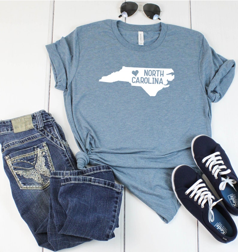 May include: A blue t-shirt with a white outline of the state of North Carolina and the text "I love North Carolina" with a heart symbol.