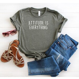May include: A green t-shirt with the text "ATTITUDE IS EVERYTHING" in white lettering.