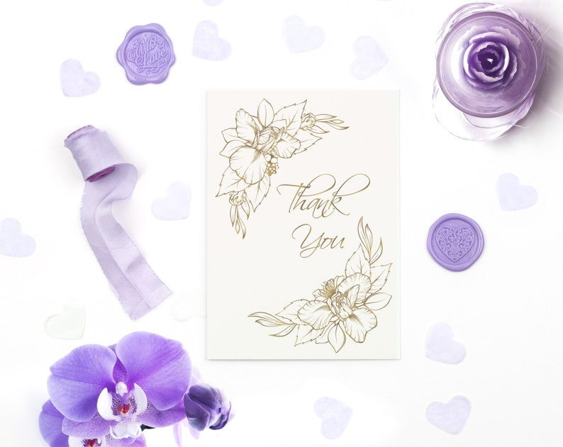 Pode incluir: Um cart&atilde;o branco com um design floral dourado e o texto "Obrigado". O cart&atilde;o &eacute; cercado por cora&ccedil;&otilde;es roxos e uma fita roxa.