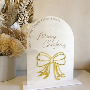 Merry Christmas with Custom Family Names Arched Plywood Sign Freestanding With Bow