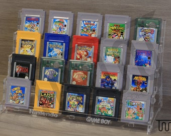 May include: A clear acrylic display stand with multiple shelves for storing and displaying Game Boy cartridges. The stand has a black label that reads "Nintendo Game Boy". The stand is filled with various Game Boy cartridges, including titles like "Donkey Kong Country", "Zelda", "Pokemon", and "Tetris".
