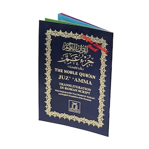 May include: A dark blue softcover book titled The Noble Qur'an Juz' 'Amma with gold foil lettering and an ornate gold border. The cover features Arabic calligraphy, English text, and a small logo at the bottom, with colorful page edges visible.