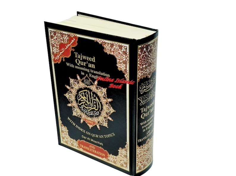 May include: A hardcover book titled "Tajweed Qur'an" with English translation. The book has a black cover with gold and red decorative patterns and text. The spine also features text. The book is for Islamic studies.