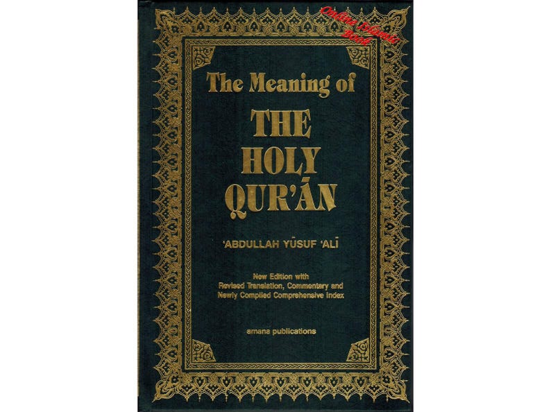 May include: A hardcover book titled "The Meaning of The Holy Qur'an" by Abdullah Yusuf Ali. The cover is dark teal with gold lettering and a decorative gold border. The book is a new edition with revised translation, commentary, and index.