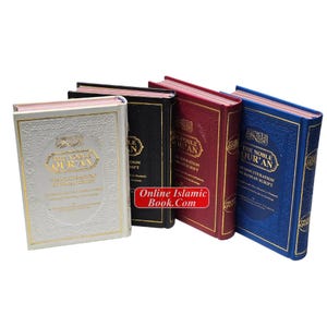Op de afbeelding: Vier hardcover boeken met gouden letters en randen. De boeken zijn in wit, zwart, bordeauxrood en blauw. De tekst "THE NOBLE QUR'AN" is zichtbaar op de covers. De website "Online Islamic Book.Com" is ook zichtbaar.