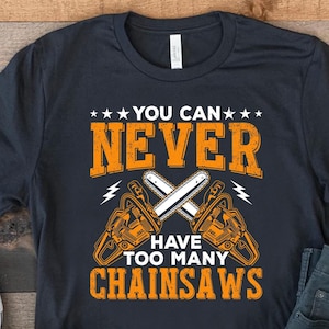 以下が含まれることがあります： 2本のチェーンソーが交差したグラフィックと「You can never have too many chainsaws」というテキストが書かれた黒いTシャツ。