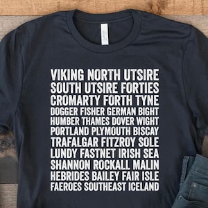 Peut inclure: Un t-shirt noir avec du texte blanc listant divers endroits du Royaume-Uni et des régions environnantes. Le texte indique "Viking North Utsire, South Utsire Forties, Cromarty Forth Tyne, Dogger Fisher German Bight, Humber Thames Dover Wight, Portland Plymouth Biscay, Trafalgar Fitzroy Sole, Lundy Fastnet Irish Sea, Shannon Rockall Malin, Hebrides Bailey Fair Isle, Faeroes Southeast Iceland".