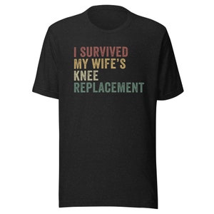 May include: Black t-shirt with a vintage-style graphic that reads "I survived my wife's knee replacement."