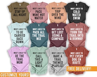 May include: A collection of colorful t-shirts with various phrases printed on them, including "Stay Up All Night," "Pack Wine Not Water," and "Trip Over The Wind." The shirts come in a variety of colors and are available for customization.
