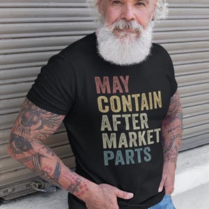 May include: A black t-shirt with a vintage-style graphic that reads "MAY CONTAIN AFTER MARKET PARTS".