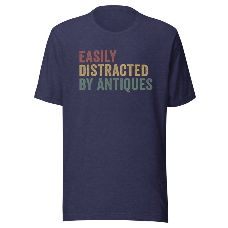 May include: A navy blue t-shirt with the text "EASILY DISTRACTED BY ANTIQUES" in a vintage style font with red, orange, yellow, and green colors.