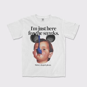 Puede incluir: Camiseta blanca con un gr&aacute;fico de un beb&eacute; con orejas de Mickey Mouse y una cuchara azul. El texto en la camiseta dice "I'm just here for the snacks. Mickey shaped, please."