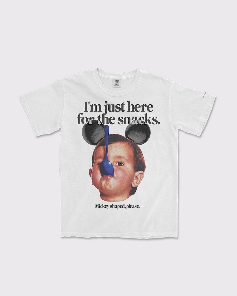 Puede incluir: Camiseta blanca con un gr&aacute;fico de un beb&eacute; con orejas de Mickey Mouse y una cuchara azul. El texto en la camiseta dice "I'm just here for the snacks. Mickey shaped, please."