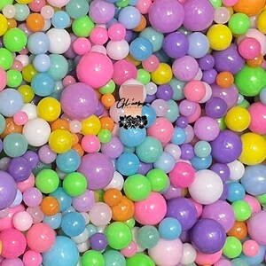 May include: A close-up image of a variety of pastel-colored balls. The balls are made of plastic and have a glossy finish. The colors include pink, blue, green, yellow, and purple.
