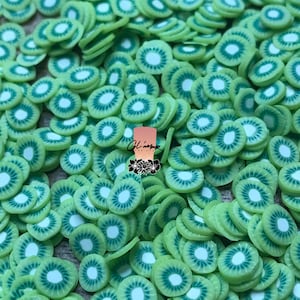 May include: A large quantity of green and white kiwi fruit slices made of polymer clay. The slices are arranged in a random pattern and are perfect for crafting and decorating.